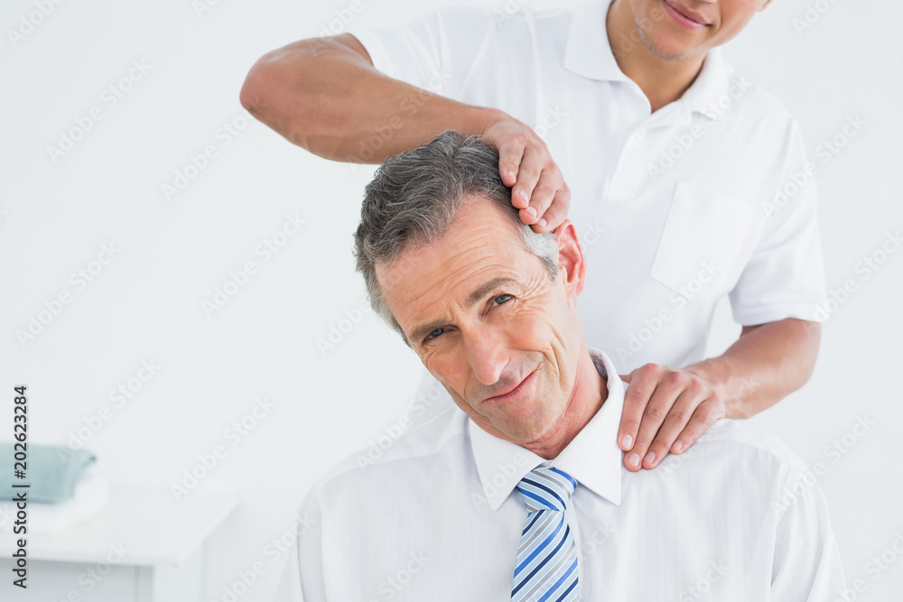 Male chiropractor doing neck adjustment Male chiropractor doing neck adjustment