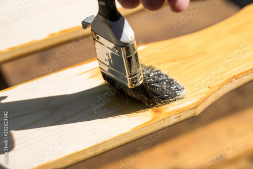 Closeup of paintbrush with brown glaze for weather protection photo