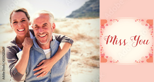 Happy hugging couple on the beach looking at camera against backgrounds working