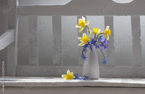 Fototapeta Naklejka Na Ścianę i Meble -  spring flowers in vase on white wooden bench