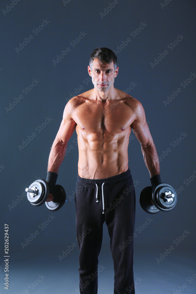 Handsome muscular man working out with dumbbells. Personal fitness instructor. Personal training. Handsome muscular man working out with dumbbells. Personal fitness instructor. Personal training.