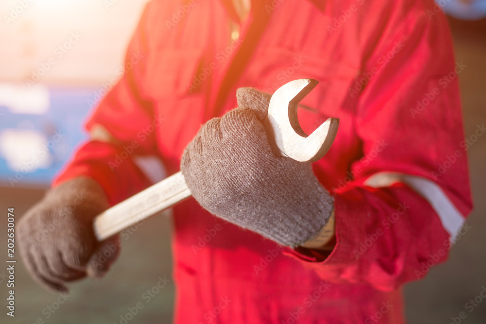 automechanic in overalls holding wrench or spanner automechanic in overalls holding wrench or spanner