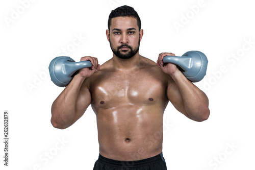 Muscular man lifting heavy kettlebell 