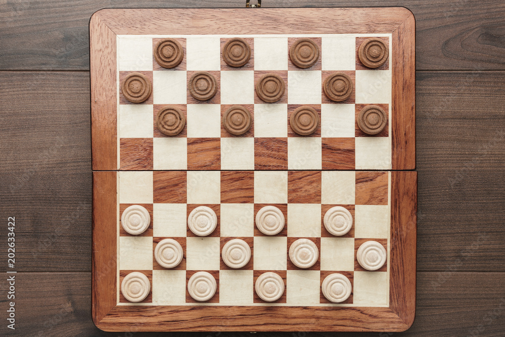 top view of wooden draughts game on brown table background top view of wooden draughts game on brown table background