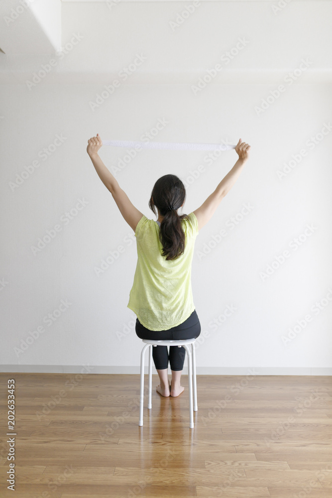 Fototapeta premium タオルを使ってストレッチ運動をする女性