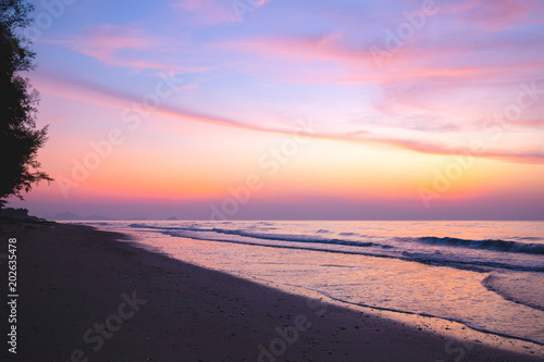 Nice sky  clouds and sun above the beautiful sea and sand beach with little waves at the morning moment.