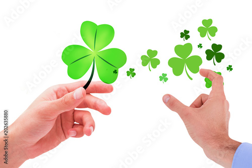 Businessman holding hand out in presentation against shamrock © vectorfusionart