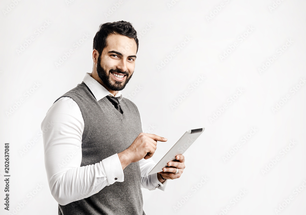 Bearded smiling businessman holds tablet computer on isolated white background Bearded smiling businessman holds tablet computer on isolated white background