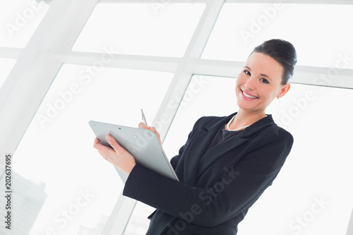 Portrait of a smiling elegant businesswoman writing notes