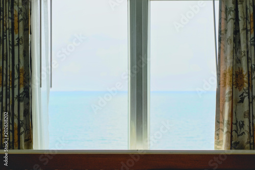 Window of the hotel with sea view in the morning time.