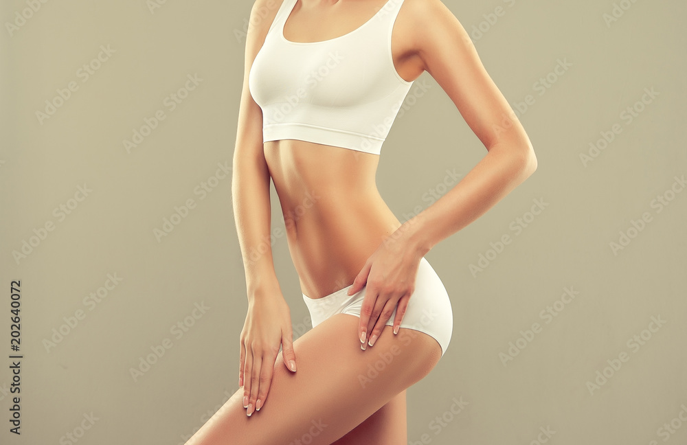 Perfect slim toned young body of the girl . An example of sports , fitness or plastic surgery and aesthetic cosmetology. 
 - obrazy, fototapety, plakaty 