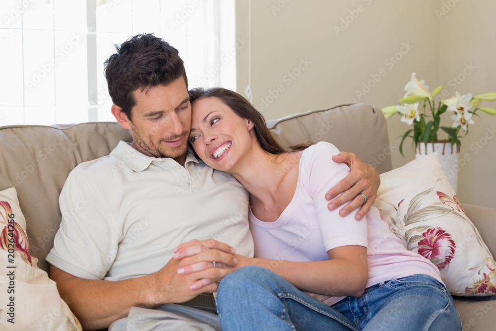 Loving couple sitting on couch at home Loving couple sitting on couch at home