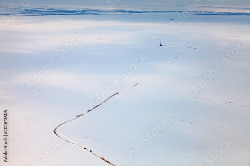 Oil derrick and road in tundra, view from above