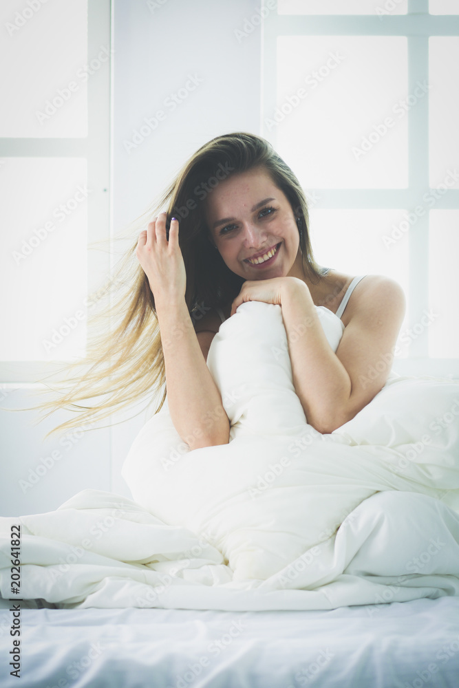 Pretty woman sitting on her bed at home Pretty woman sitting on her bed at home