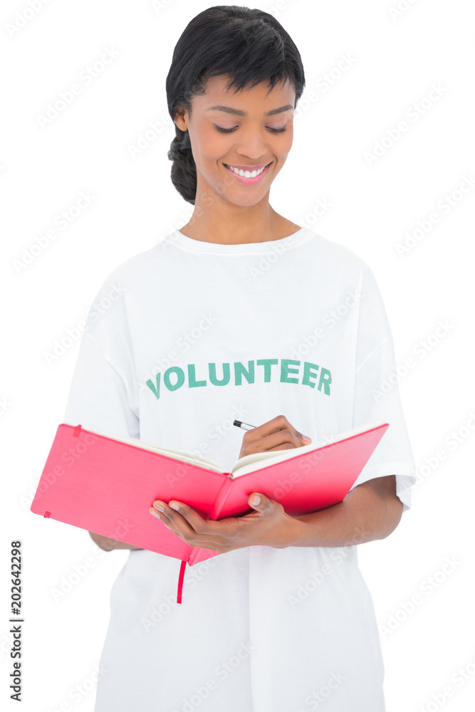 Pretty black haired volunteer writing on a notebook Pretty black haired volunteer writing on a notebook