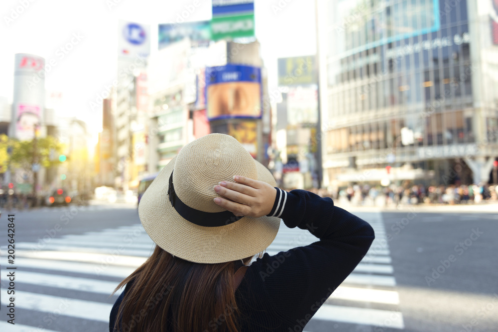 Φωτογραφία Woman is crossing the road at Shibuya junction in Tokyo, Japan.