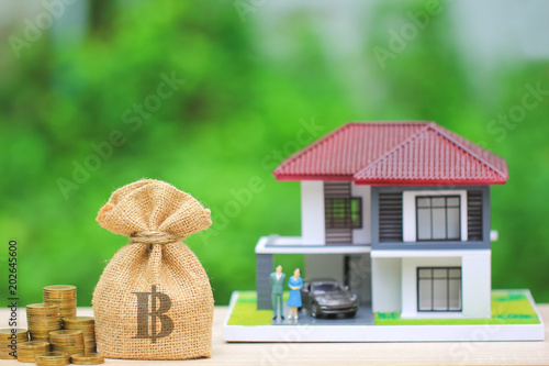 Stack of gold coins money and bag with model house on natural green background, Investment and Real estate concept  photo