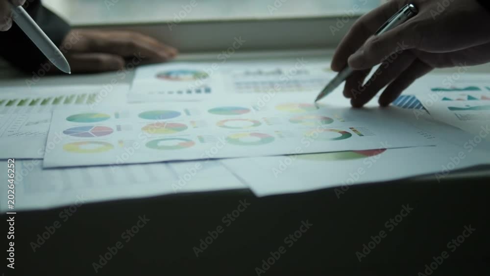 Business people talking with charts in office. Business people talking with charts in office.