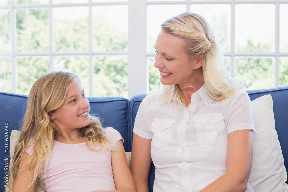 Mother and daughter looking at each other on sofa Mother and daughter looking at each other on sofa