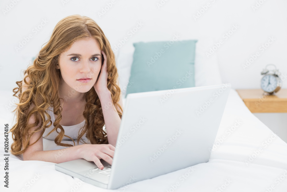 Serious casual young blond with laptop in bed Serious casual young blond with laptop in bed