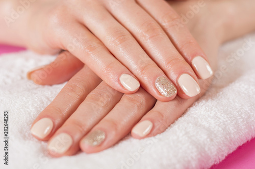 Young girls hands with cream color nails polish on fingers. Manicure and beauty hands concept. Close up  selective focus.
