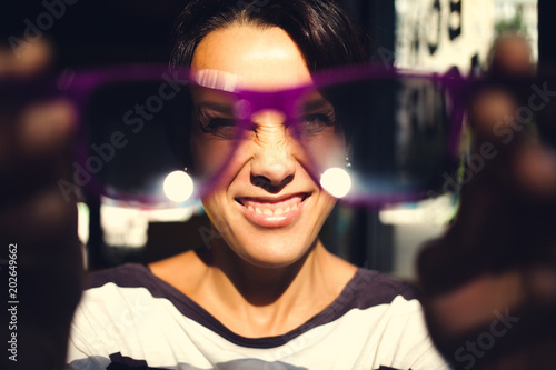 girl looks through sunglasses. © zhukovvvlad