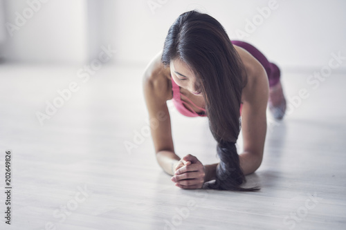 Woman doing plank exercises on mat photo