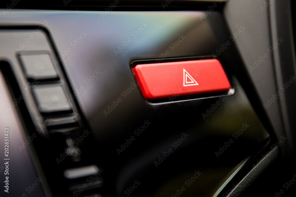 Emergency button in the modern car on front dashboard close up.