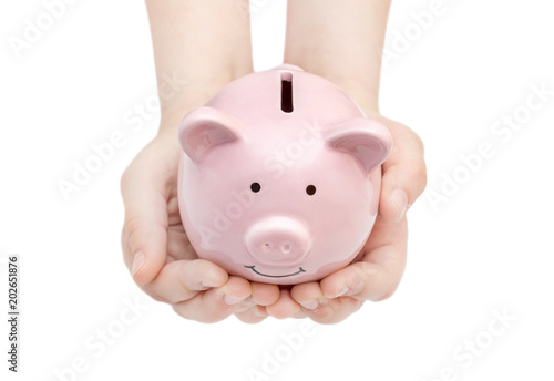 Child s hands holding piggy bank. Isolated on white.