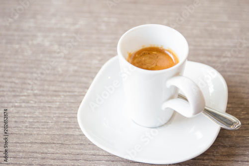 Shot of espresso in the white cup close up.