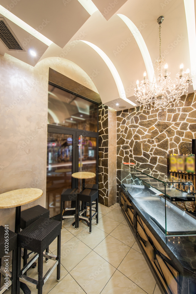 Naklejka premium Contemporary decorated interior of pizza restaurant with shelves and seats