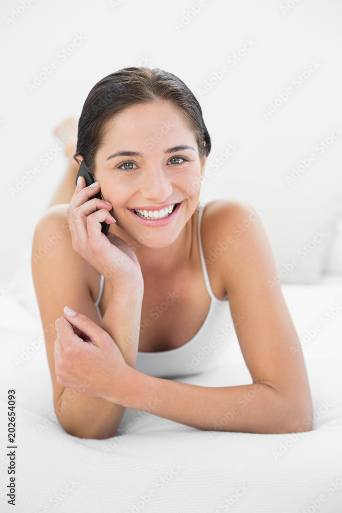 Portrait of a smiling woman using mobile phone in bed Portrait of a smiling woman using mobile phone in bed