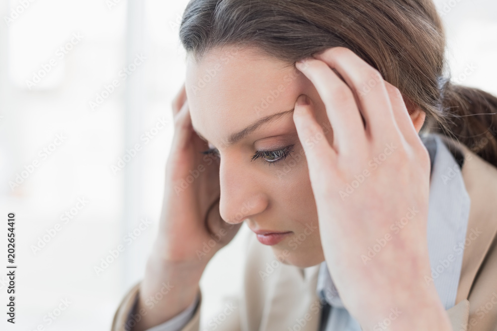 Close up side view of businesswoman suffering from headache Close up side view of businesswoman suffering from headache