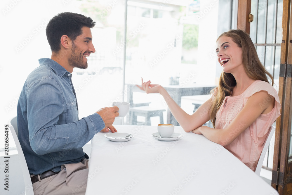 Fototapeta premium Side view of a smiling couple at coffee shop