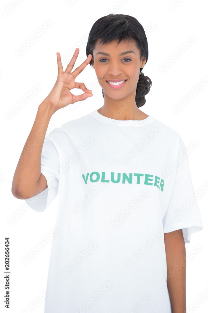 Cheerful black haired volunteer making an okay gesture Cheerful black haired volunteer making an okay gesture