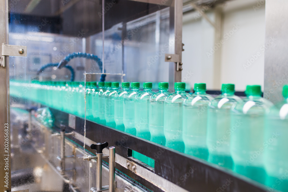 Bottling plant - Water bottling line for processing and bottling pure spring water into bottles. Selective focus. 