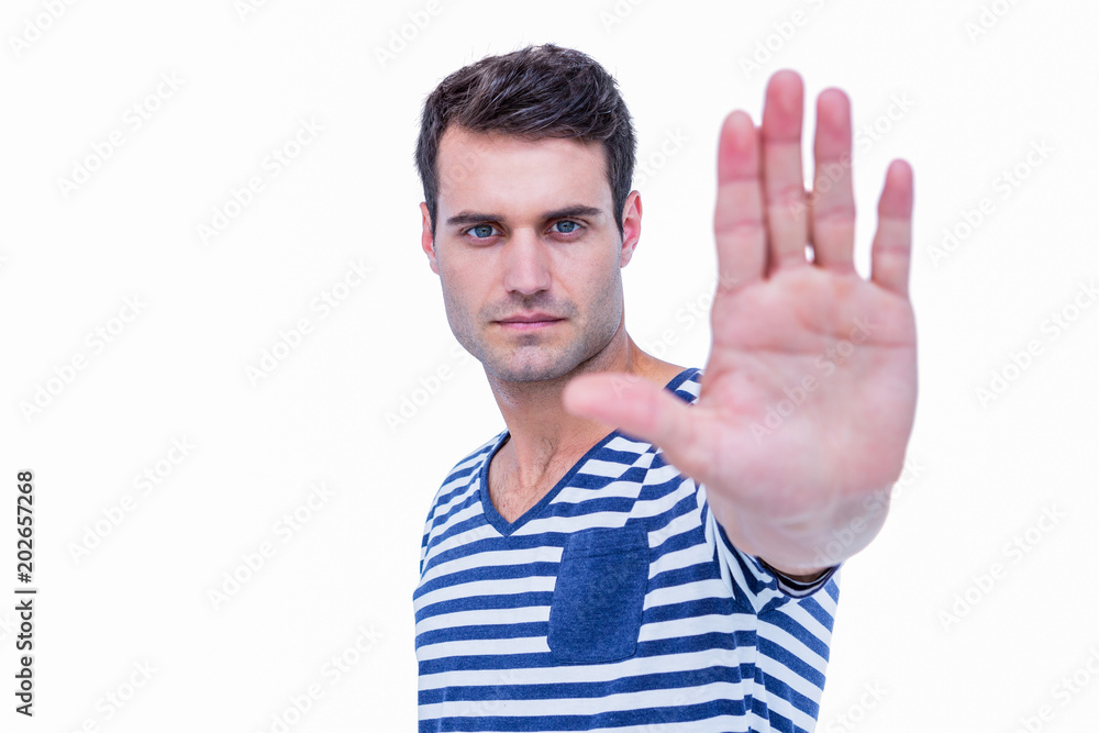 Handsome hipster looking at camera and showing stop sign with hand Handsome hipster looking at camera and showing stop sign with hand