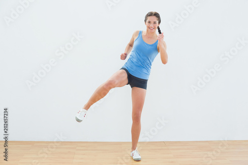 Sporty woman stretching leg in fitness center