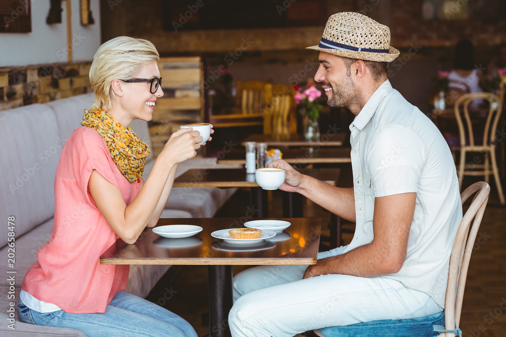 Cute couple on a date talking over a cup of coffee Cute couple on a date talking over a cup of coffee