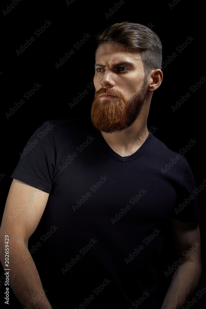 Vertical portrait of serious young man with folded and crossing hands standing Isolated on black background and looking forward Confident concept Mockup Vertical portrait of serious young man with folded and crossing hands standing Isolated on black background and looking forward Confident concept Mockup