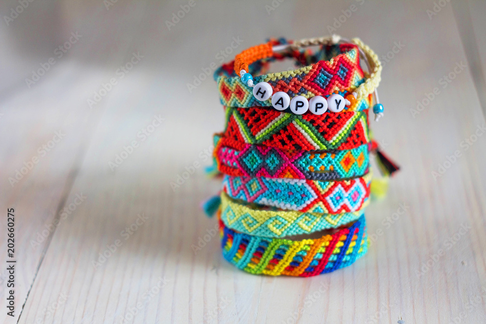 handmade friendship bracelets with colorful threads on light background