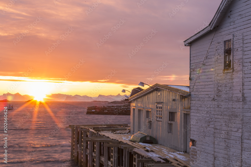 Φωτογραφία Sunrise illuminates an old wooden house in the harbor of Henning