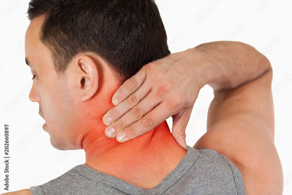 Young male massaging his back against a white background Young male massaging his back against a white background