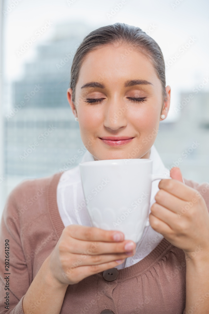 Relaxed gorgeous businesswoman holding cup of coffee Relaxed gorgeous businesswoman holding cup of coffee
