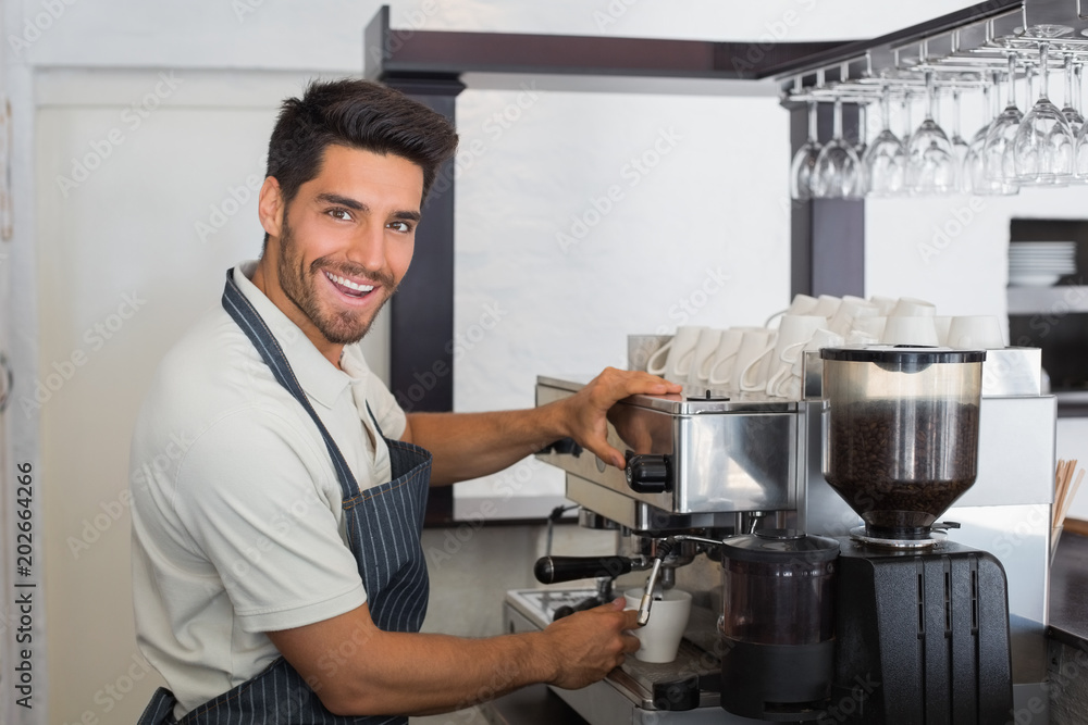 Smiling waiter making cup of coffee at coffee shop Smiling waiter making cup of coffee at coffee shop