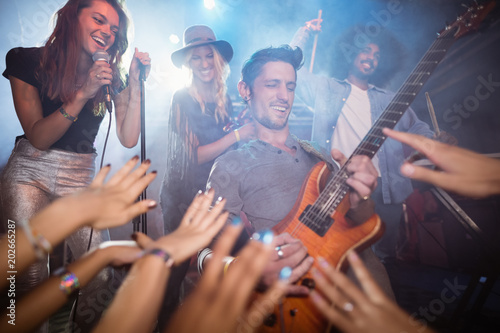 Guitarist performing by crowd at nightclub