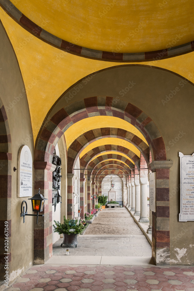 Gallery of arches and colonnade inside the cemetery of San Candido, Italy.