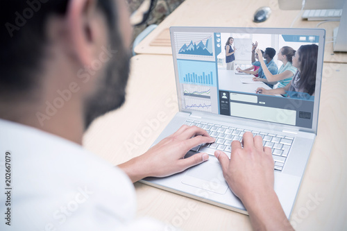 Business interface against cropped businessman using laptop at desk