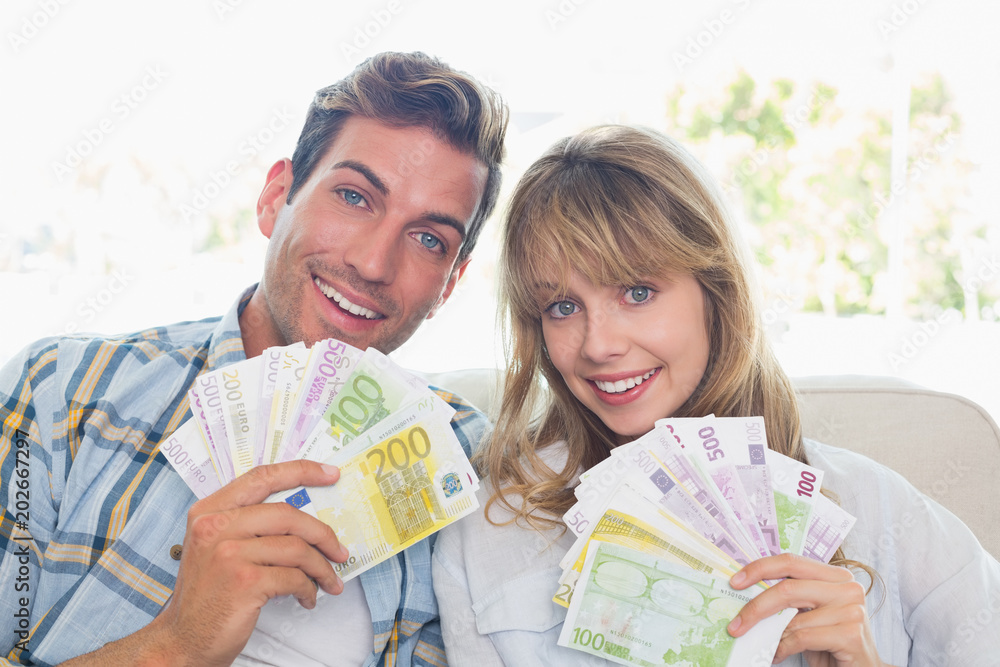 Φωτογραφία Portrait of a young couple holding fanned out Euro notes