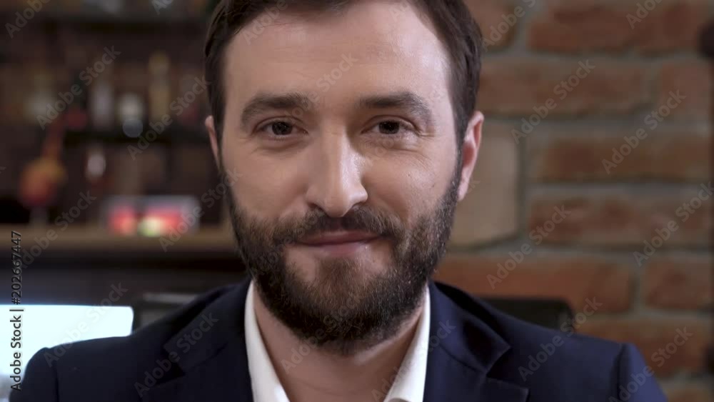 Well dressed, confident young man with a beard is lookig confidently at the camera. Closeup. Well dressed, confident young man with a beard is lookig confidently at the camera. Closeup.